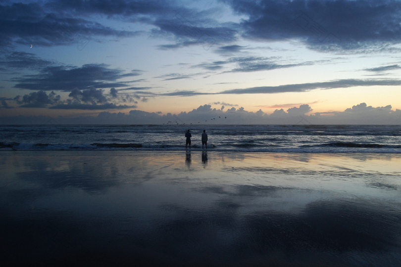 两个人站在海边的剪影