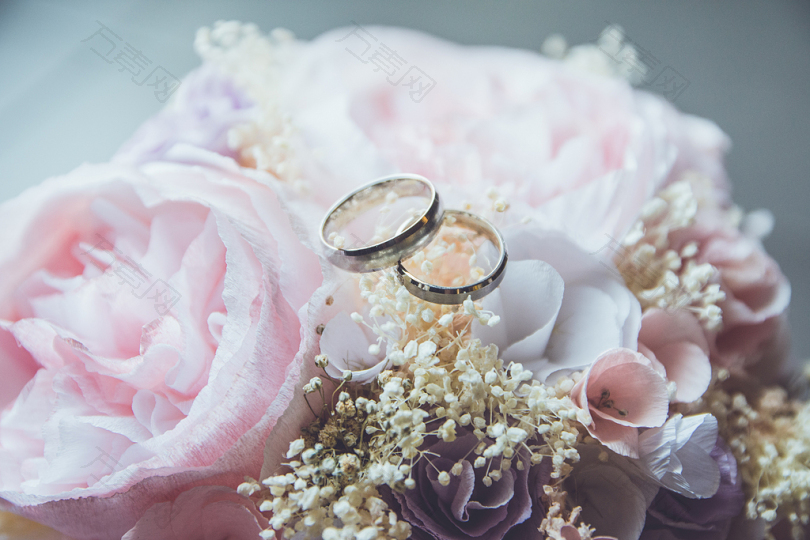 粉色玫瑰花束上的金色婚戒