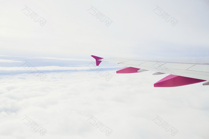 白天拍摄的白色和粉色飞机飞行