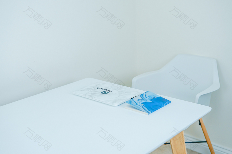 蓝色的书在白色的桌子前面有扶手椅