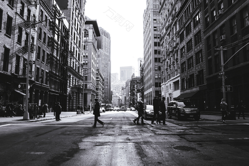 穿越街道的人的灰度摄影