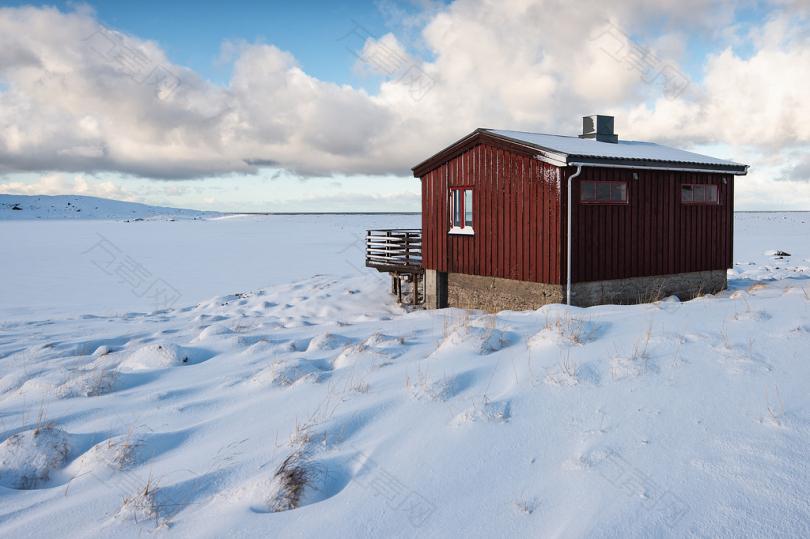 白天被雪覆盖的红色和棕色木屋
