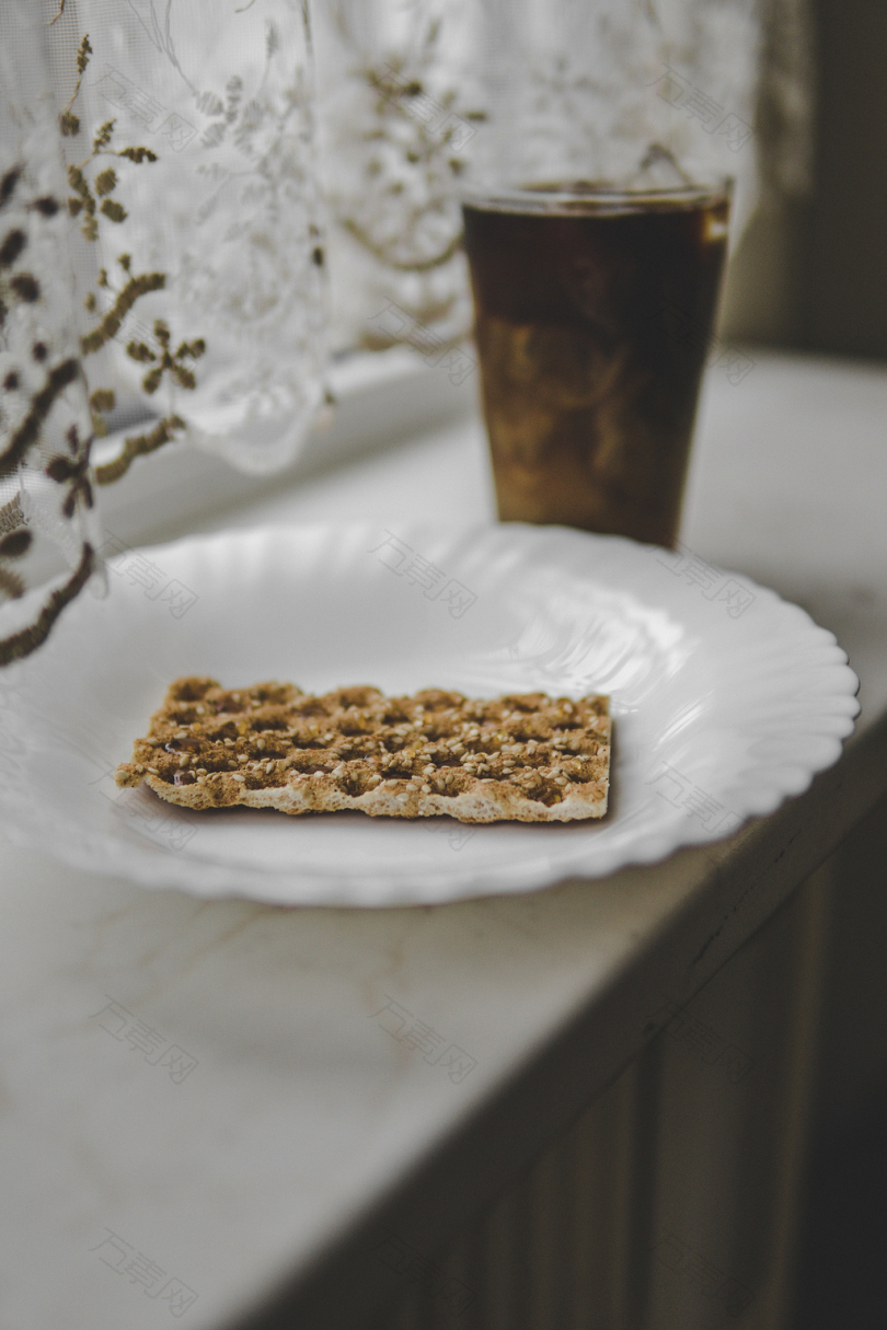 圆形白色陶瓷板附近的棕色液体满饮杯饼干