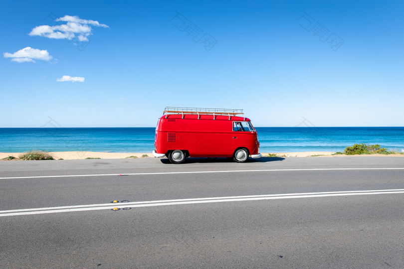 海边的柏油路上的红色厢式货车