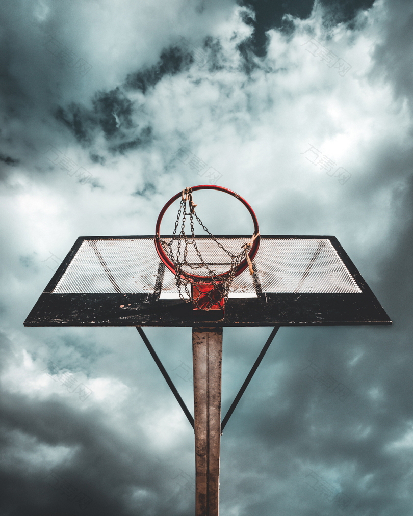 白天云天下黑白相间金属便携式篮球篮的低角度照片