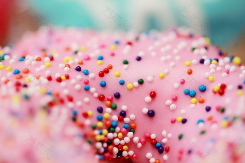 带彩虹喷头的粉红冰冻甜甜圈