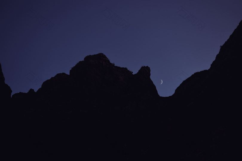 剪影月亮岩石和高山